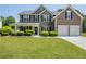 Charming two-story home featuring manicured lawn, stone accents, and a welcoming covered front porch at 868 Cork Oak Ln, Lawrenceville, GA 30045