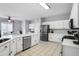 Well-lit kitchen featuring white cabinets, stainless steel appliances, and tile flooring, open to dining at 868 Cork Oak Ln, Lawrenceville, GA 30045