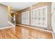 Open-concept living space featuring hardwood floors, bright windows with shutters, and access to the staircase at 4002 Turnstone Nw Dr, Kennesaw, GA 30152