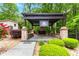 Outdoor brick pergola with black frame, ceiling fan, and lush greenery at 4002 Turnstone Nw Dr, Kennesaw, GA 30152