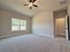 Bright bedroom featuring a ceiling fan, large window, and neutral carpet at 5706 Urban Village Way # 4, Tucker, GA 30084