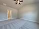 Neutral bedroom features a ceiling fan, neutral carpet, and an entrance to another room at 5706 Urban Village Way # 4, Tucker, GA 30084
