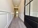 Entrance hallway with gray wood flooring, white wainscoting, leading towards a brightly lit living area at 5706 Urban Village Way # 4, Tucker, GA 30084