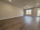 Bright and airy living room featuring wood floors, a ceiling fan, and a door that leads to the backyard at 5706 Urban Village Way # 4, Tucker, GA 30084