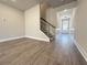 Spacious living area with staircase, wood flooring, and white wainscoting detail throughout at 5706 Urban Village Way # 4, Tucker, GA 30084