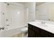 This bathroom has a shower/tub combo, dark brown vanity, white countertop, and tile flooring at 2249 Knoxhill Se Vw, Smyrna, GA 30082
