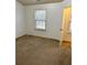 A bedroom with neutral colored walls and carpet and a window letting in natural light at 2249 Knoxhill Se Vw, Smyrna, GA 30082