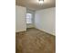 A simply designed bedroom with neutral-colored walls and carpet, plus a window with natural light at 2249 Knoxhill Se Vw, Smyrna, GA 30082