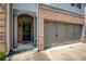 Close-up of the townhome's brick and gray-toned entryway, black front door and attached garage at 2249 Knoxhill Se Vw, Smyrna, GA 30082