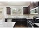 Stylish kitchen features stainless appliances, dark cabinets, granite countertops, and hardwood flooring at 2249 Knoxhill Se Vw, Smyrna, GA 30082