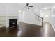 Open-concept living room featuring hardwood floors, a fireplace, and modern ceiling fan at 2249 Knoxhill Se Vw, Smyrna, GA 30082