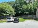 Exterior shot of a parking area with a white van and a black SUV, set against a backdrop of lush green trees at 2249 Knoxhill Se Vw, Smyrna, GA 30082