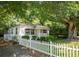 Charming cottage-style home with a white picket fence and mature trees providing ample shade at 311 Henry Aaron Ave, Atlanta, GA 30310
