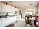 Open kitchen with white appliances, dining table, and tile floors, seamlessly connecting to living area at 311 Henry Aaron Ave, Atlanta, GA 30310