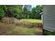 Private backyard featuring a wooden fence, mature trees, and a lush green lawn at 3858 Glenlake Dr, Douglasville, GA 30134
