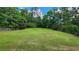 Large, well-manicured backyard with lush lawn and mature trees, framed by a classic wooden fence at 3858 Glenlake Dr, Douglasville, GA 30134