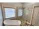 Bright bathroom featuring a soaking tub, glass enclosed shower and large window at 3858 Glenlake Dr, Douglasville, GA 30134