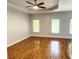 Spacious bedroom with hardwood floors, tray ceiling and abundant natural light from three windows at 3858 Glenlake Dr, Douglasville, GA 30134