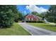 Exterior elevation features driveway, mature landscaping, and a well maintained lawn at 3858 Glenlake Dr, Douglasville, GA 30134