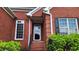 Inviting front entrance with a storm door, brick steps, and manicured shrubs at 3858 Glenlake Dr, Douglasville, GA 30134