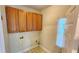 Compact laundry room with overhead cabinets and connections for a washer and dryer at 3858 Glenlake Dr, Douglasville, GA 30134