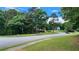 Curvy street view featuring well-manicured lawns, trees, and landscaping at 3858 Glenlake Dr, Douglasville, GA 30134
