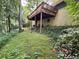 View of the backyard of a home with a brick exterior and wooden deck surrounded by lush greenery at 2636 Whiteleigh Ne Ct, Atlanta, GA 30345