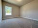 Cozy bedroom with a large window offering natural light and plush carpeting for comfort at 5710 Urban Village Way # 6, Tucker, GA 30084
