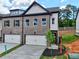 Two-story townhome boasts a brick facade, single-car garage, and well-maintained landscaping at 5710 Urban Village Way # 6, Tucker, GA 30084