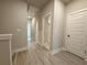 Hallway featuring neutral paint, modern flooring, and a view into other rooms through white-framed doors at 5710 Urban Village Way # 6, Tucker, GA 30084