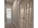 Hallway featuring views into other rooms through glass doors and neutral paint throughout at 5710 Urban Village Way # 6, Tucker, GA 30084