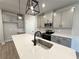 Modern kitchen with stainless steel appliances, gray cabinets, quartz countertops, and stylish pendant lighting at 5710 Urban Village Way # 6, Tucker, GA 30084