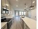 Bright, open-concept kitchen with gray cabinetry, quartz countertops, stainless steel appliances, and pendant lights at 5710 Urban Village Way # 6, Tucker, GA 30084