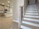 View of the home's staircase featuring modern wood flooring, white risers, and black iron railing at 5710 Urban Village Way # 6, Tucker, GA 30084