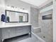 Modern bathroom featuring double vanity with marble countertop and tiled walk-in shower with bench at 214 Kingsley Way, Woodstock, GA 30188