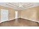 Bright bedroom with hardwood floors, neutral walls, tray ceiling and multiple windows for natural light at 214 Kingsley Way, Woodstock, GA 30188