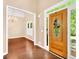 Inviting foyer with hardwood floors, decorative front door, and adjacent living area with chandelier at 214 Kingsley Way, Woodstock, GA 30188