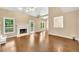 Open-concept living room with fireplace, hardwood floors, and natural light from large windows at 214 Kingsley Way, Woodstock, GA 30188