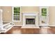 Bright living room featuring a fireplace, hardwood floors, and a large window at 214 Kingsley Way, Woodstock, GA 30188