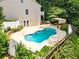 Backyard oasis with a sparkling inground pool surrounded by lush landscaping and a white fence at 214 Kingsley Way, Woodstock, GA 30188