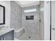 Contemporary walk-in shower with marble tile, built-in bench, and niche for toiletries at 214 Kingsley Way, Woodstock, GA 30188