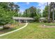 Charming single-story home with gray siding, black shutters, manicured lawn, and mature trees at 3131 Garden Lane Dr, Marietta, GA 30062
