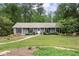 Charming single-story home with gray siding, black shutters, a well-manicured lawn, and mature trees at 3131 Garden Lane Dr, Marietta, GA 30062