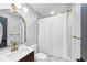 Bathroom with an arched mirror, gold hardware, and a white shower curtain at 3807 Greenhill Dr, Chamblee, GA 30341