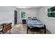 Bright bedroom with two windows, sleek black door, and minimalist furnishings at 3807 Greenhill Dr, Chamblee, GA 30341