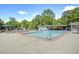 Community pool with umbrellas, lounge chairs, and covered pavilion surrounded by mature trees at 3807 Greenhill Dr, Chamblee, GA 30341