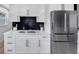 Close up of kitchen with a stainless steel refrigerator, black backsplash, and white cabinets at 3807 Greenhill Dr, Chamblee, GA 30341