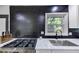 Close-up on kitchen, showcasing stainless steel appliances, black backsplash, and marble counters at 3807 Greenhill Dr, Chamblee, GA 30341