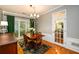 Sunlit dining room with a chandelier, hardwood floors, a view of the yard, and access to another room through a French door at 515 Rosedown Way, Lawrenceville, GA 30043