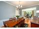 Open-concept dining room with chandelier, wood floors, and views into the office space, perfect for entertaining at 515 Rosedown Way, Lawrenceville, GA 30043